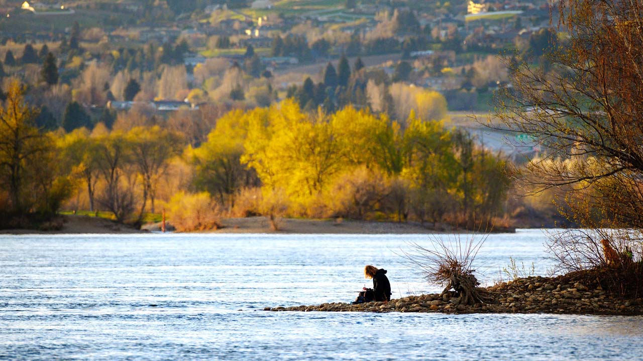 Solitary man by a river bank